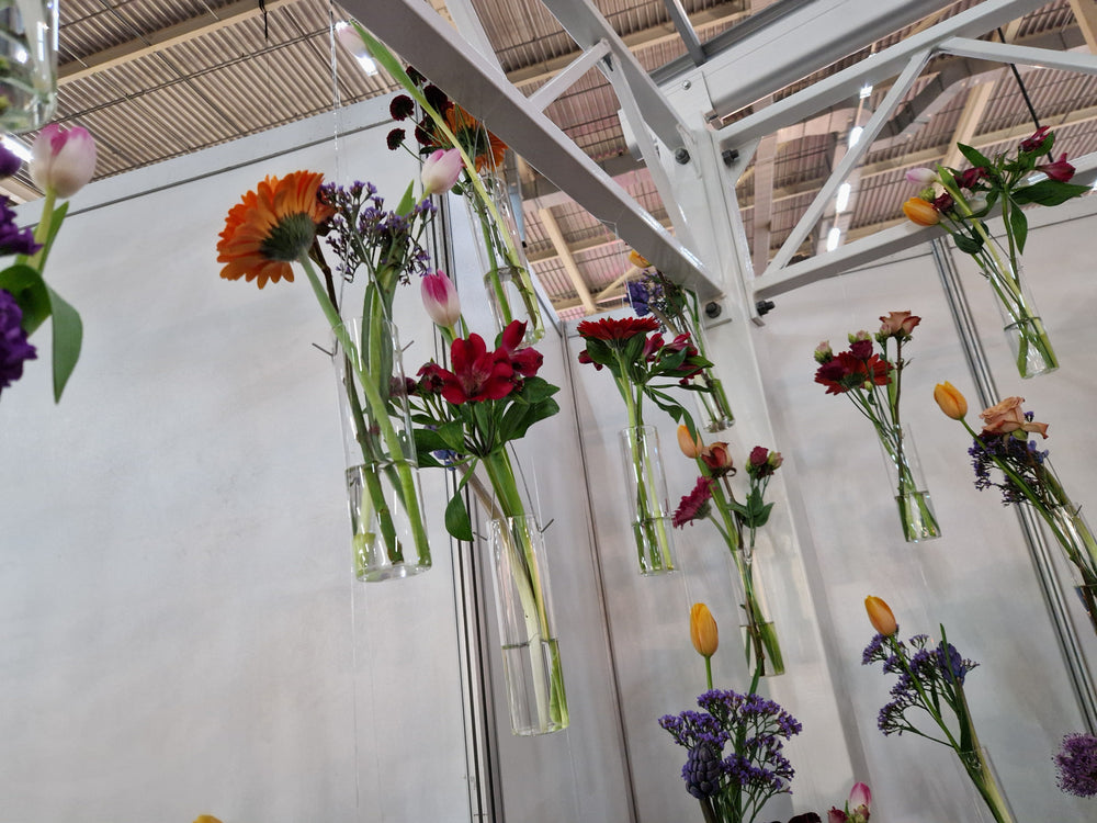 Etalagedraad toepassingsfoto onzichtbare decoratie draad met hangende bloem vaasjes op een beursstand